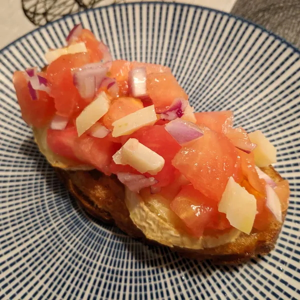 Bruschetta de tomate, cebolla de Figueres y queso manchego con base de rulo de cabra y pan Turris