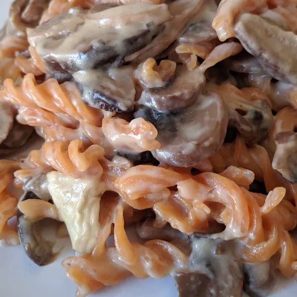 Fusilli de lentejas rojas con cebolla caramelizada, rulo de cabra y setas a la crema