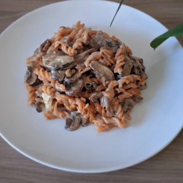 Fusilli de lentejas rojas con cebolla caramelizada, rulo de cabra y setas a la crema
