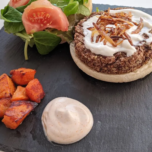 Hamburguesa de azukis, quinoa y semillas de cañamo acompañada de boniatos estilo bravas